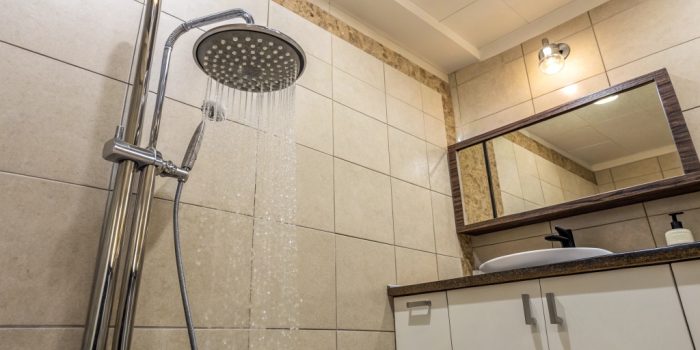 Bathroom shower with a shower head not perfectly centered above the shower area