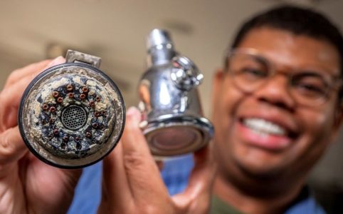 Homeowner cleaning mineral deposits from push-pull valve components using brush and vinegar solution