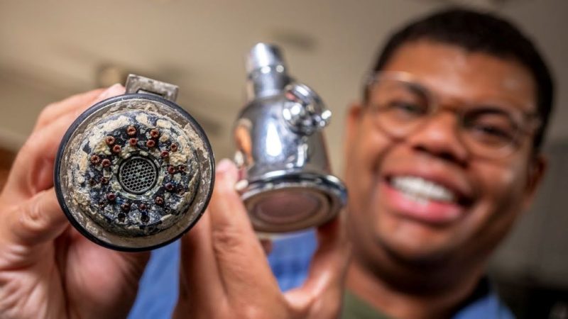 Homeowner cleaning mineral deposits from push-pull valve components using brush and vinegar solution