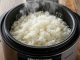Close-up of steaming white rice from Elite Gourmet ERC003B cooker on a wooden table