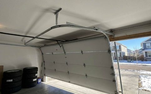 Technician inspecting low overhead garage door track alignment