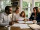 Family reviewing paperwork while buying a house in Alabama with a real estate agent