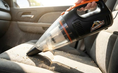 Compact Armor All portable car vacuum cleaning dusty vehicle interior seat.
