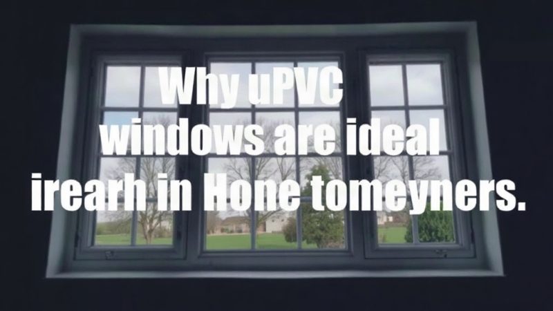 A white-framed window with text overlaid on the glass and a view of a green lawn and trees.